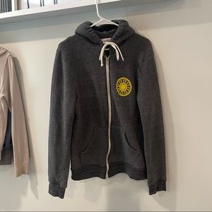 SoulCycle zip-up sweatshirt with yellow wheel on front and white skull on back